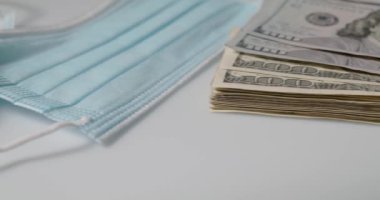 Virüs ve diğer sağlık risklerine karşı korunmak için bir grup yüz maskesi, ABD 'den gelen 100 dolarlık banknotların yanında.