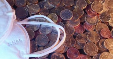 Birçok Euro madeni parasının üstü açıktır. Bozuk paraların üzerinde FFp2 maskesi. Sağlık ve masraflar