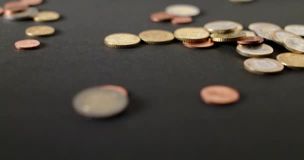 欧元硬币和其他硬币的焦点不集中在黑色背景 孤立的钱 — 图库视频影像