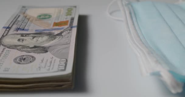 在堆积起来的外科面具和Ffp2 N95防护面具旁边堆放了100美元的钞票 — 图库视频影像