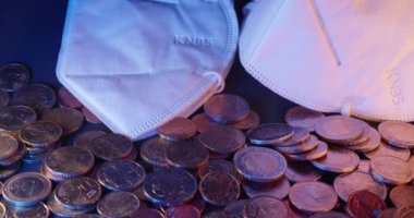 Birçok Euro madeni parasının üstü açıktır. Bozuk paraların üzerinde FFp2 maskesi. Sağlık ve masraflar