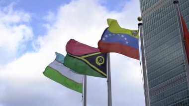 Manhattan, New York 'taki Birleşmiş Milletler binasında Özbekistan, Venezuela ve Vanuatu bayrakları havada uçuşuyor. Yavaş çekim bayrakları dalgalanıyor