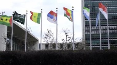 Slow Motion Bayrakları rüzgarda dalgalanıyor, bayrak direğinde bayraklar sallıyor. New York 'taki Birleşmiş Milletler' deki uluslararası topluluk.