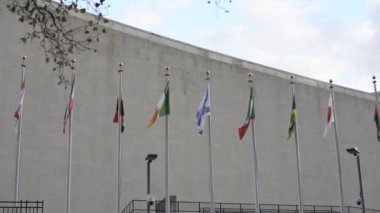 New York 'taki Birleşmiş Milletler Binası önünde ağır çekimde bayraklar. İsrail, Japonya, İtalya ve İrlanda rüzgarda bayrak sallıyor. Yavaş hareket