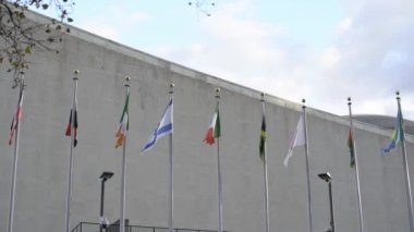 Rüzgarda yavaş hareket eden bayraklar. Birleşmiş Milletler bayrakları New York 'ta. İsrail, İtalya, Japonya Kazakistan ve dünyanın bayrakları yavaşça dalgalanıyor.