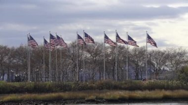 New Jersey 'de Flag Plaza' da bayraklar. Yavaş çekimde ABD bayrakları rüzgarda dalgalanıyor. Amerika Birleşik Devletleri rüzgarda bayrak salladı
