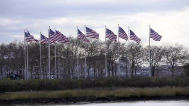New Jersey 'deki Flag Plaza, rüzgarda dalgalanan ABD bayrakları. Amerika Birleşik Devletleri ağır çekimde bayrak sallıyor