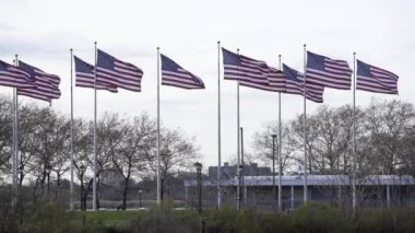 New Jersey 'deki Flag Plaza, rüzgarda dalgalanan ABD bayrakları. Amerika Birleşik Devletleri ağır çekimde bayrak sallıyor