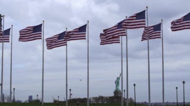 Amerika Birleşik Devletleri ağır çekimde bayrak sallıyor. Arka planda özgürlük heykeli. Amerika 'da özgürlük ve özgürlük.