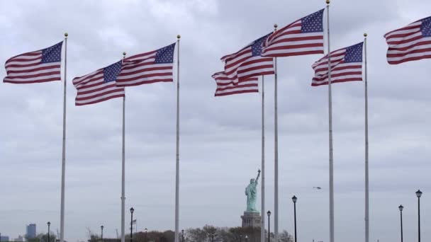 自由女神像 美利坚合众国国旗迎风飘扬 慢动作的旗帜挥动着 自由和自由的象征在乌云密布 暴风雨的天空下 危险中的自由概念 — 图库视频影像