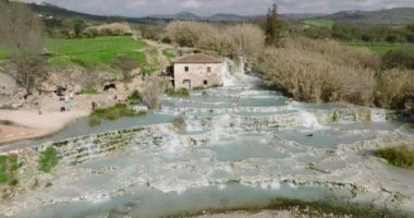 Saturnia, İtalya, Şubat 2022: Toskana, İtalya 'da Satürn termal havuzu. Güzel şelale yüksek açılı manzara