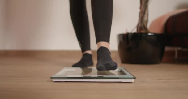 Jonge Vrouw Stapt Schaal Haar Gewicht Controleren Resultaten Van Trainingssessies — Stockvideo
