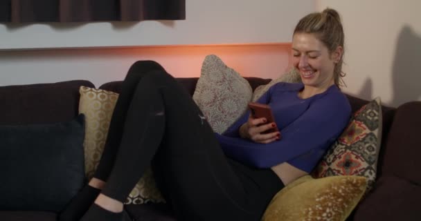 Vrouw Zitten Bank Controleren Haar Smartphone Lachen Tijdens Het Lezen — Stockvideo
