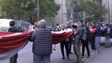 Manhattan, ABD - 11. Kasım 2021: Gaziler Günü Geçidi sırasında New York 'ta dev ABD bayrağı katlayan gaziler. Vatansever erkek ve kadınlar