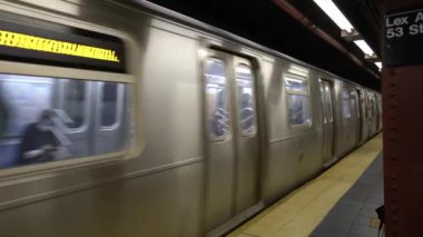 New York, ABD - 12. Kasım 2021: Metro treni Lexington Bulvarı metro istasyonuna vardı. Manhattan 'da metroya binip inen insanlar. Yüz maskesi takan yolcular