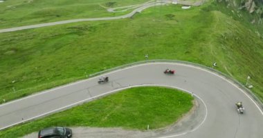 Motosikletlerin Alplerdeki keskin yol üzerindeki hava manzarası. Motorların yukarıdan aşağı görünümü