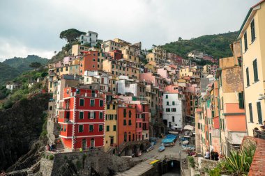 Riomaggiore, İtalya - 11 Haziran. 2021: Riomaggiore 'un güzel manzarası, 5 Terre' deki popüler ve ünlü turizm merkezi. Akdeniz kıyısındaki Renkli Evler.