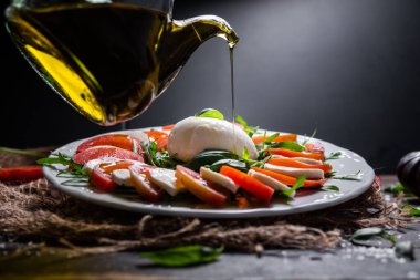 Tipik İtalyan inek ya da bufalo mozzarella peyniri, roka, fesleğen, domates, zeytinyağı ve tuz, tipik Caserta ve Saleno, İtalya.