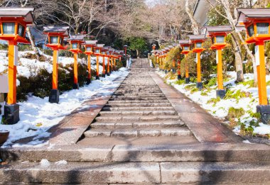 Kışın tapınağın yolundaki klasik lamba ve sokak lambasıyla çevrili taş merdiven ve Asya Japonya 'daki tapınakta açık hava ışığı ve yürüyüş yolu için eski bir retro fener.