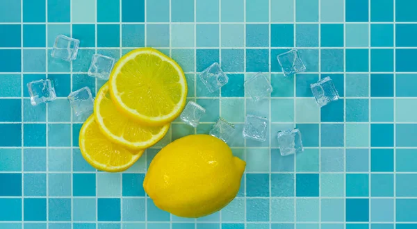 青いタイルのグリッドテーブルの上にレモン 氷とスライス新鮮なレモンのトップビュー バーテンダーはバーでパーティーで飲むためのフルーツカクテルや新鮮なジュースを準備します — ストック写真