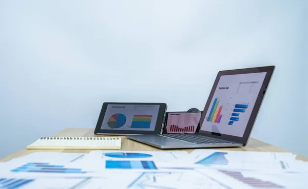 ticari veri grafiği tablet, dizüstü bilgisayar, mobil, sunum yapmak için beyaz kopya alanı olan belge, profesyonel işadamı iş veri grafiği üzerinde çalışıyor