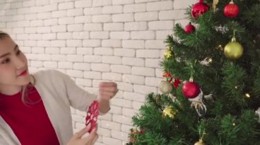 Kadınlar Noel ağacında kar süsü süsler, çiftlerin yaşam tarzı romantizm aşıkları mutlu noel tatilleri evde yeni yıldan önce ağaçla