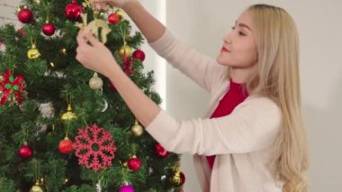 Kadınlar Noel günü gülümser ve geyik süsü süsler. Romantik çiftlerin yaşam tarzı. Mutlu noeller.