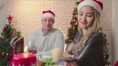 Çiftler mutlu bir amigo şarabı ve Noel günü birlikte kameraya bakın. Romantik çiftlerin yaşam tarzı. Mutlu noeller, Noel tatilleri.