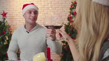 Mutlu bir çift Noel günü birlikte şarap içer ve eğlenir. Romantik aşıkların yaşam tarzı. Yılbaşından önce Noel ağacıyla mutlu bir Noel tatili.