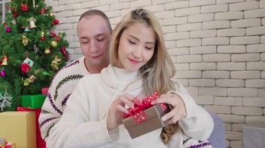 Mutlu çift, Noel hediyesi kutusunu alır. Romantik aşıkların yaşam tarzı. Yılbaşından önce Noel ağacıyla mutlu Noeller diler.