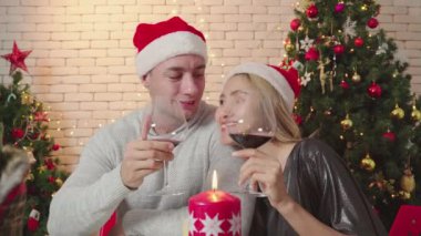 Mutlu bir çift, Noel günü birlikte şarap içer ve birlikte yaşar. Romantik çiftlerin yaşam tarzı. Mutlu noeller, Noel tatilleri.