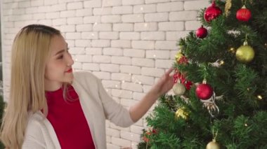 Kadınlar noel ağacında balo süsü süsler, çiftlerin yaşam tarzı aşıklar mutlu noeller Noel tatilleri evde yılbaşından önce ağaçla.
