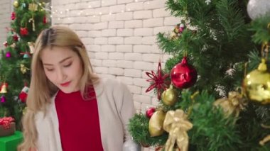 Kadınlar, Noel ağacında altın geyik süsü süsler. Romantik çiftlerin yaşam tarzı. Mutlu noeller.