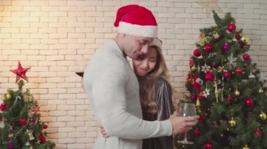Çiftler Noel 'de şarapla birlikte mutlu tatlı dans eder. Romantik aşıkların yaşam tarzı. Mutlu noeller, Noel tatilleri.