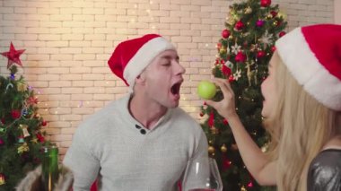 Mutlu çift Noel günü elma yer. Romantik aşıkların yaşam tarzı. Yılbaşından önce Noel ağacıyla mutlu Noeller.