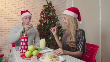 Mutlu çift, Noel günü şarap içer. Romantik aşıkların yaşam tarzı. Yılbaşından önce Noel ağacıyla mutlu Noeller diler.
