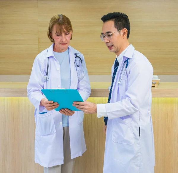 Doktor erkek ve kadın birlikte hasta sağlık raporunu tartıştılar. Steteskoplu doktor, hastanedeki hastanın sağlığını tedavi etti.
