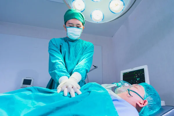 Doktor kalp masajı kardiyopulmoner hastaya. Ameliyathane, ameliyathane veya hastalar için ameliyathane altında.