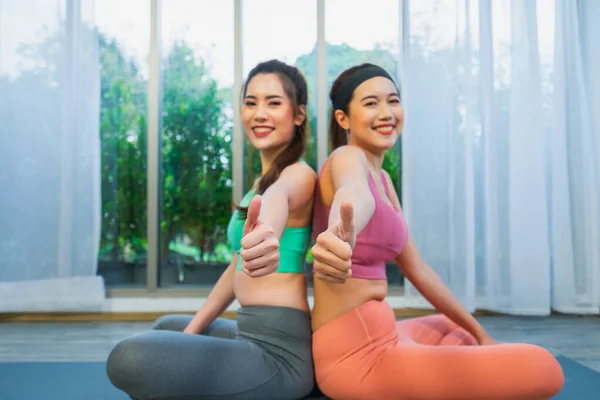 Genç Igbt kadınları birlikte egzersiz yapar, başparmaklarını birlikte kaldırır, yoga sporlarında mutlu ve eğlenceli kadınları seven bir çift olarak yaşarlar.