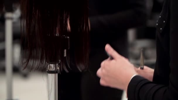 Kaukasisches Mädchen in schwarzer Kleidung schneidet einer Schaufensterpuppe den Kopf ab