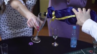 Barmen bir ziyaretçiye şampanya doldurur.