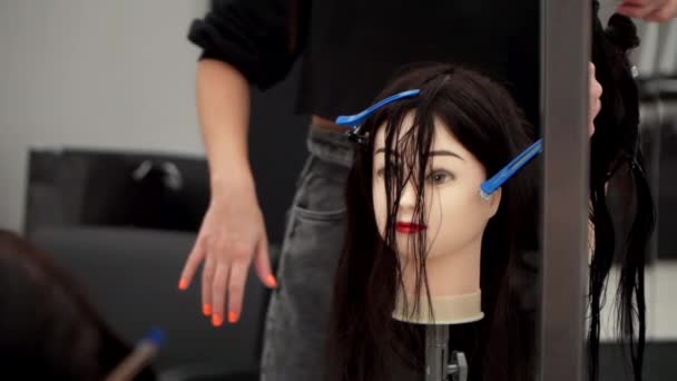 Vit flicka i svarta kläder skär huvudet av en skyltdocka — Stockvideo
