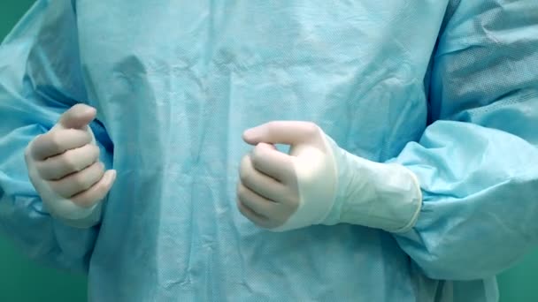 Eine Krankenschwester hilft dem Chirurgen, Handschuhe anzuziehen — Stockvideo