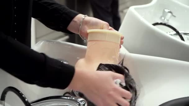 Studerande tvättar håret av skyltdockor på en frisör kurs — Stockvideo