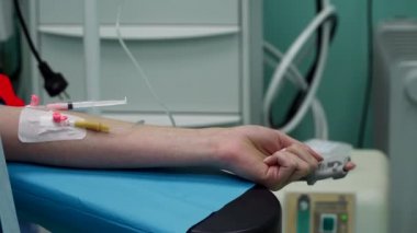 Bir klinik hastanesinde ameliyat olan beyaz bir kızın eli.