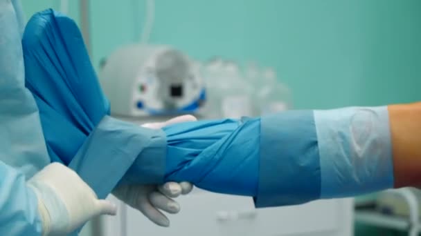 Cerrah koruyucu dokuyu hastaların bacağına takar. — Stok video