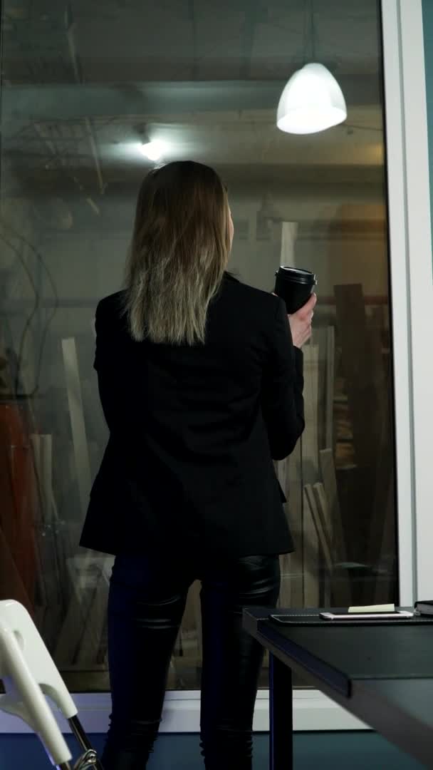 Vídeo vertical. las mujeres de negocios en pantalones de cuero bebe café en una chaqueta — Vídeo de stock