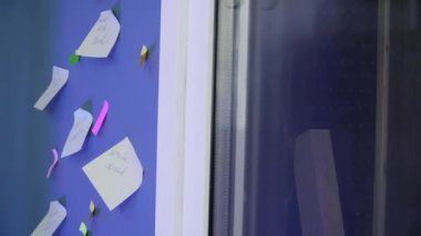 Yakın plan. Bir kadın eli duvara etiket yapıştırıyor. 