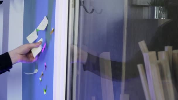 Närbild. En manlig hand klistrar ett klistermärke på en vägg — Stockvideo