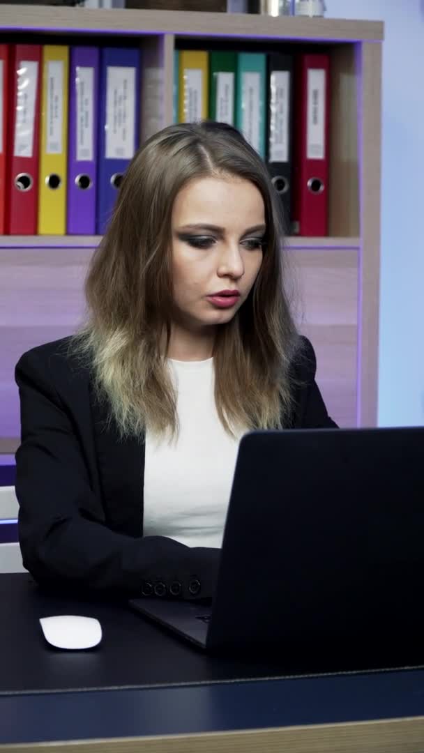 垂直ビデオだ。ヨーロッパの女の子はノートパソコンにテキストを入力しています — ストック動画